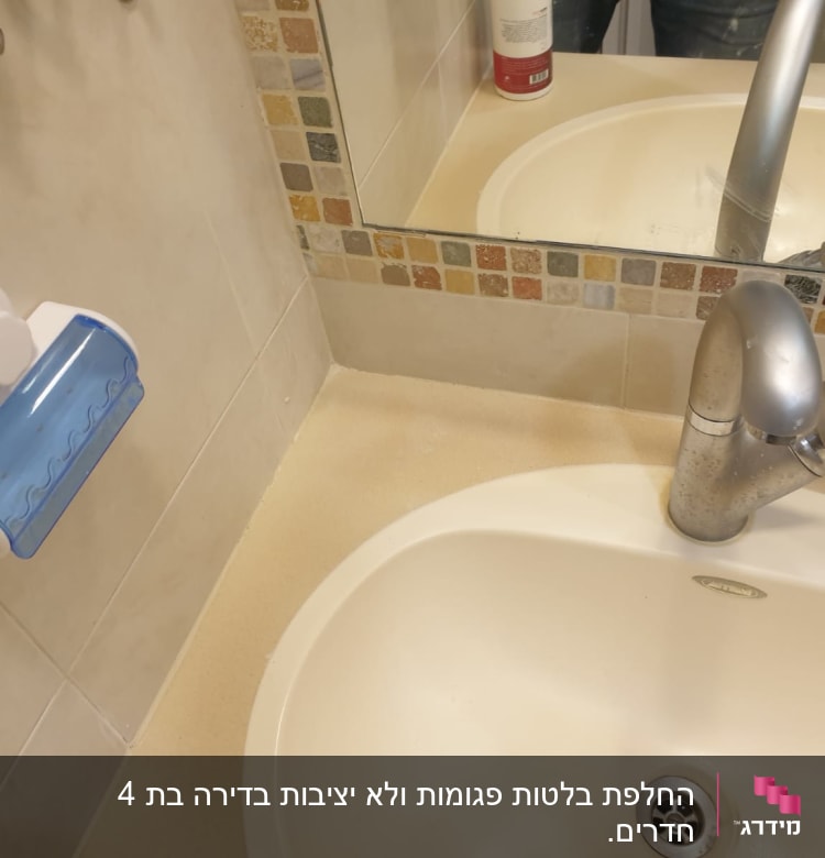 כיור עם ברז כסוף ומתקן סבון כחול